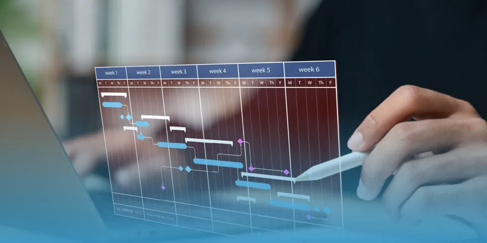 Person sat at their laptop holding an apple pencil in their left hand, editing a holographic gantt chart